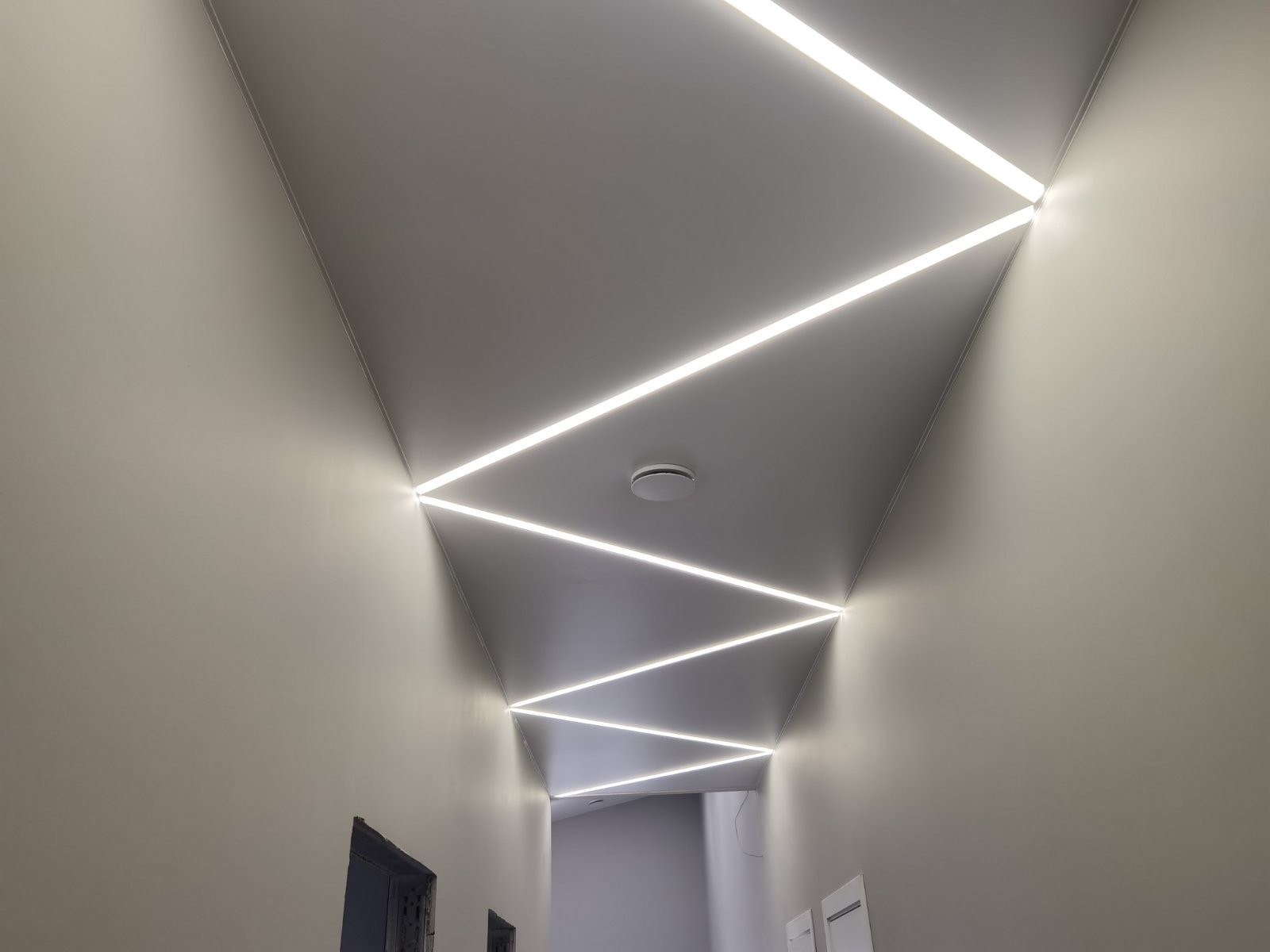 Zigzago LED linijos ilgame koridoriuje