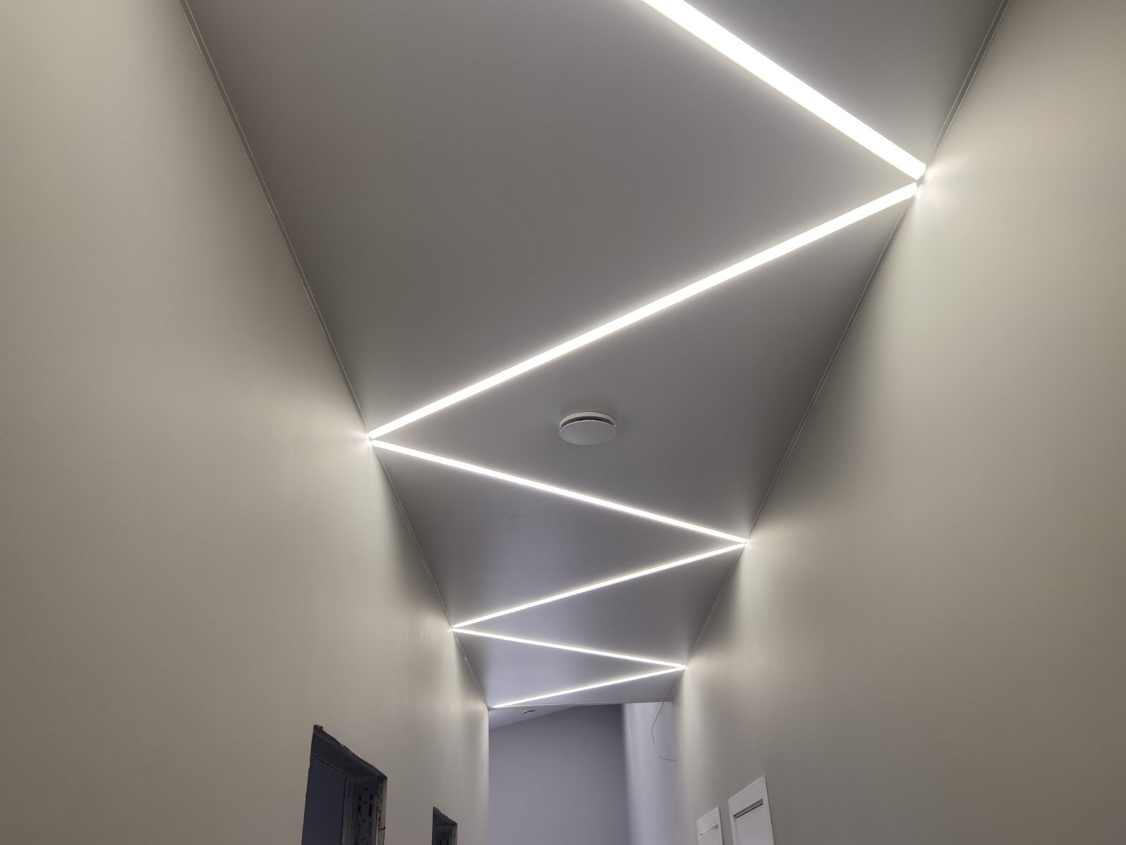 Koridoriaus įtempiamos lubos su zigzago LED linijomis — ART Ceiling darbas